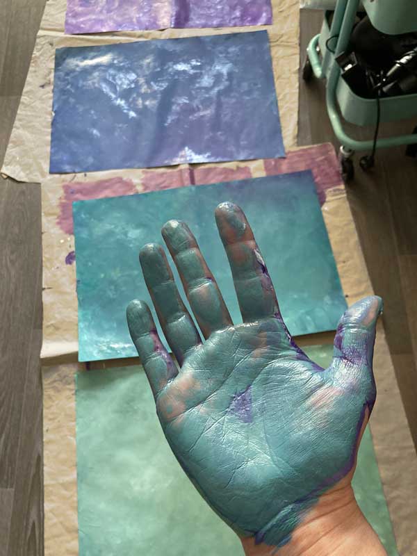 Hand von Tabea Heinicker in Aktion mit Farbe verschmiert – Beschäftigt mit Herzensarbeit