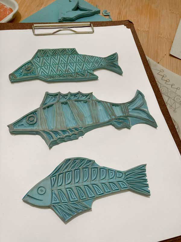 Drei fertig geschnitzte Stempel mit Fischmotiven von Therese Olivier.
