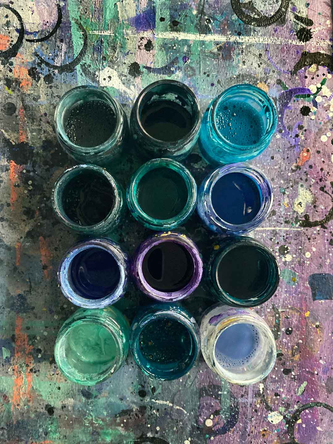Tabea Heinickers Tuschegläser mit verschiedenen Farbentönen gefüllt. Für die Sommerpost und die Herzensarbeit stehen Blau, Türkis und Lila im Fordergrund
