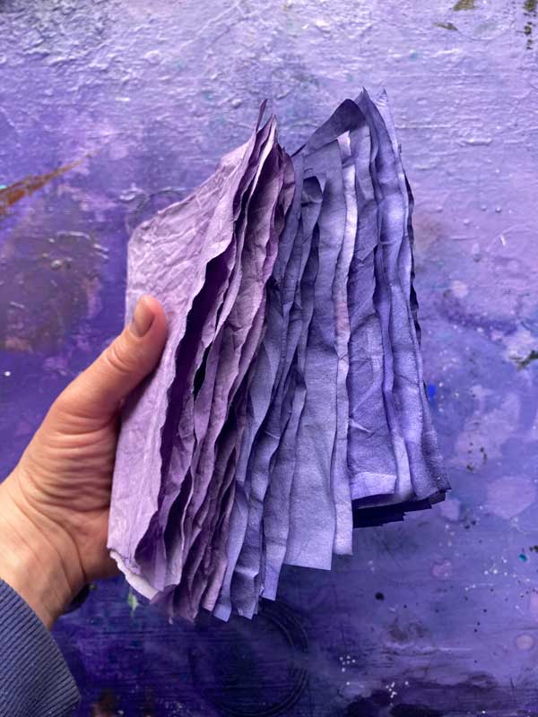 Tabeas Hand hält die fertig gefärbten Papiere in der Hand. Fühlt sich toll an und sieht wohltuend aus!