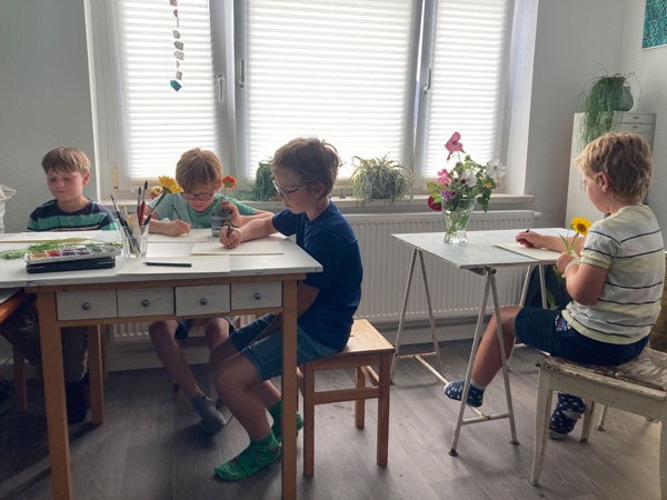 Von den Kindern lernen: Vier Kinder sitzen in Tabeas Atelier und zeichnen Blumen. Die Zeichnungen sind alle im Buch veröffentlich!