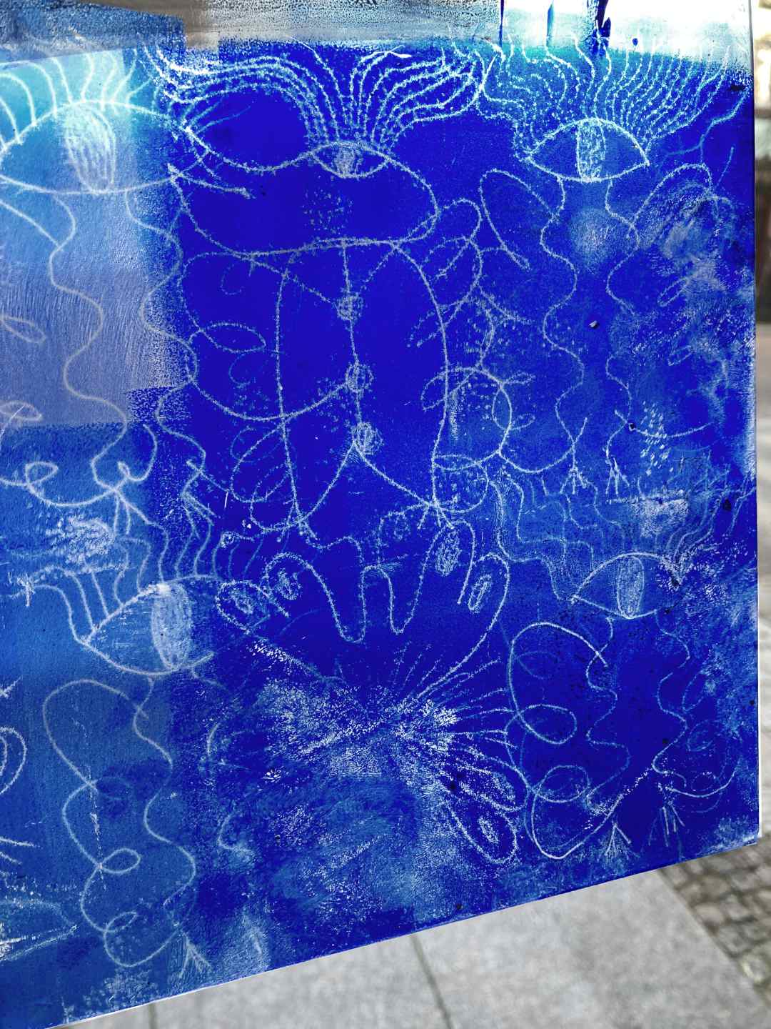 Engel im Mixed-Print: Glasscheibe mit blauer Buchdruckfarbe eingewalzt. Die Stellen, die schon gedruckt haben, weisen Zeichnungen auf. An den Stellen ist keine Farbe mehr und das Licht scheint hindurch. Sieht toll aus!