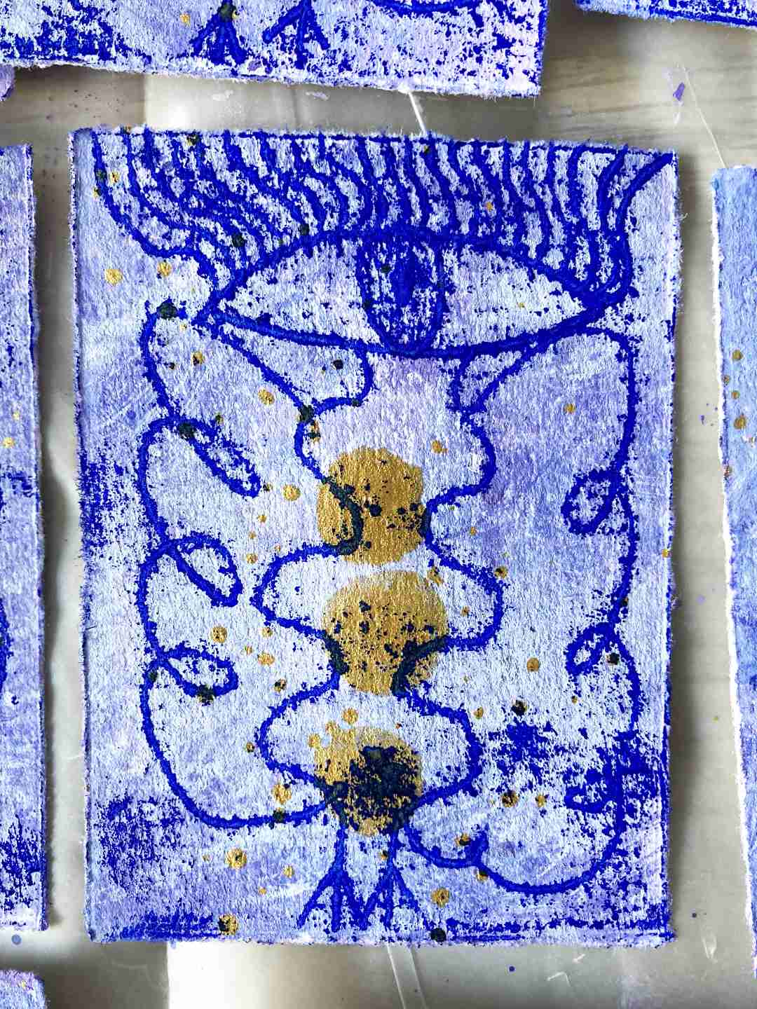 Großes Detail. Ein Engeldruck. Tanzende Linie, die mit einem rasterartigen Druck von der Glasscheibe verschmilzt. Leuchtendes Blau. Vasenartiger Körper, schlaufenartige Flügel, Vogelfüße, ein großes Auge als Kopf mit Wimpern die bis zum Rand auslaufen.